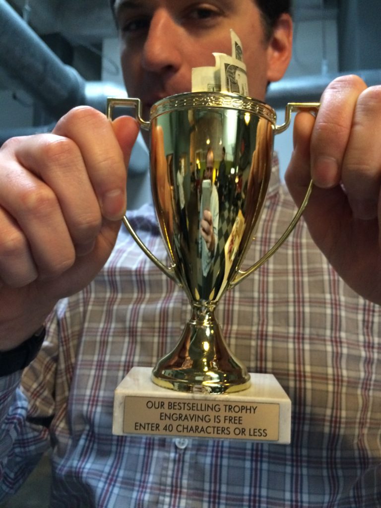 Ward holding a trophy with cash inside